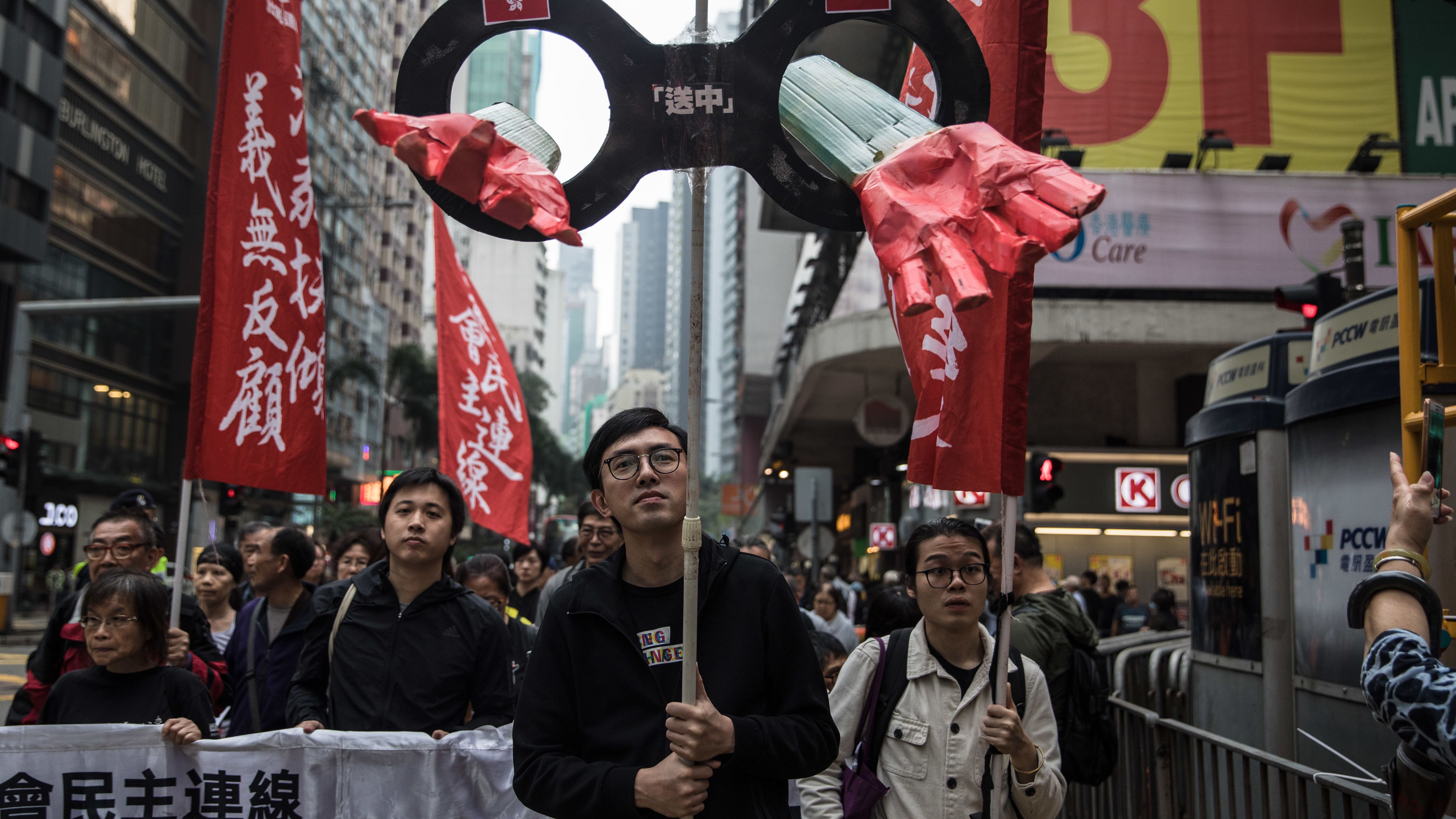 Protesters march along a street during a rally in Hong Kong on March 31, 2019, to protest against the government's plans to approve extraditions with mainland China, Taiwan and Macau.
