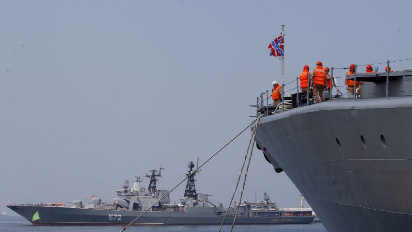 The crew of the Russian Navy destroyer Admiral Tributs secure their ship as the Russian destroyer Vinogradov, rear, prepares to dock at Manila's South Harbor Monday, April 8, 2019, in Manila, Philippines. Three ships from the Pacific Fleet of Russia, including Vinogradov and a large tanker Irkut, arrived Monday for a five-day goodwill visit to the country. Both Admiral Tributs and Vinogradov are classified as large anti-submarine ships. (AP Photo/Bullit Marquez)