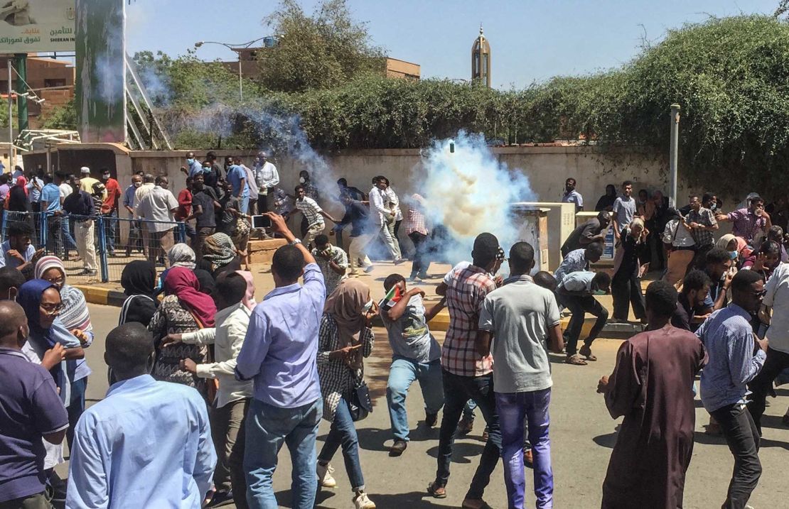 Sudanese protesters run for cover from tear gas canisters fired by security forces on Saturday.