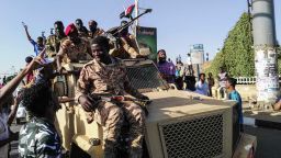 Sudanese protesters sit atop a military vehicle next to soldiers near the capital Khartoum's military headquarters on April 7, 2019, as they rally for a second day urging the military to back them. - Sudanese police fired tear gas at thousands of protesters who rallied outside the army headquarters for a second day urging the military to back them in demanding President Omar al-Bashir resign. (Photo by - / AFP)        (Photo credit should read -/AFP/Getty Images)