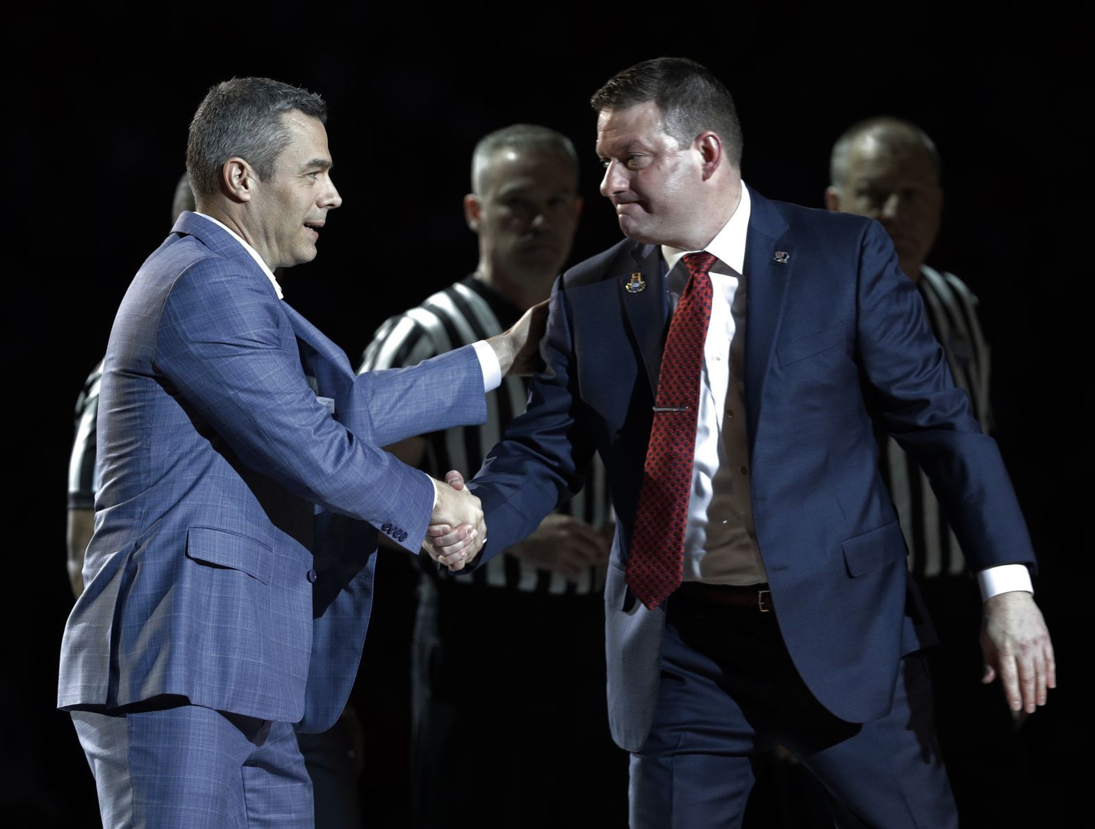 The two coaches shake hands before the game.