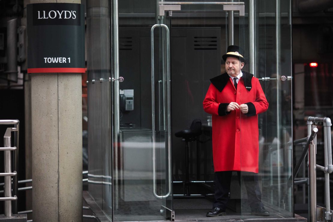 A doorman stands outside the Lloyd's building in London in 2017.
