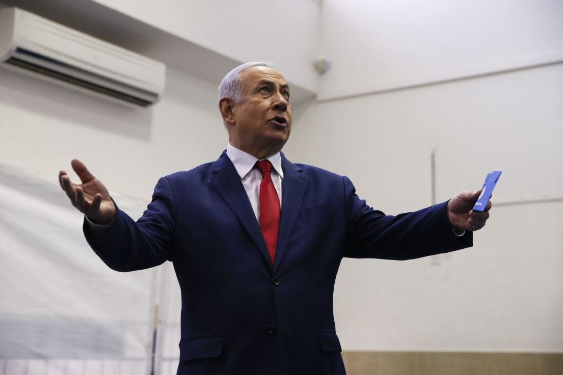 Netanyahu prepares to cast his vote on Tuesday. 