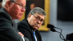 Attorney General William Barr looks over toward Assistant Attorney General for Administration, Lee J. Lofthus, left, as they appear before a House Appropriations subcommittee, on Capitol Hill, Tuesday, April 9, 2019, in Washington. Barr is defending his decision to send a letter to Congress detailing special counsel Robert Mueller's principal conclusions. He says the public would not have tolerated waiting weeks for information.(AP Photo/Andrew Harnik)