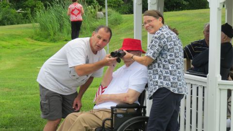 Vallieres helps a veteran spot a bird using binoculars at the New Hampshire Veterans Home. 