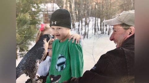 Robert Vallieres showing a peregrine falcon to boy at an Audubon camp. 