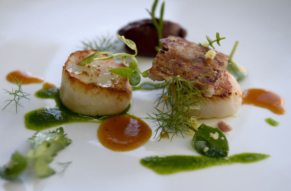 This dish is called "tripier marin," and consists of seared scallops with black pudding and pig's feet broth garnished with glasswort and watercress. 