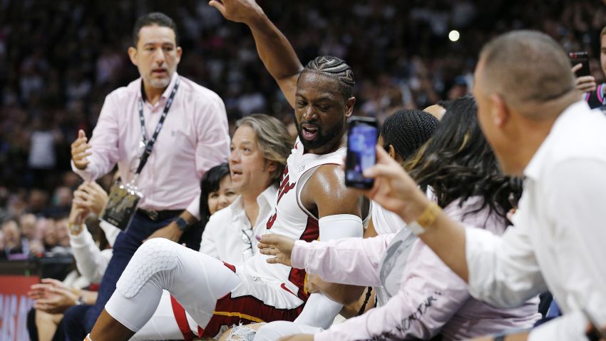 MIAMI, FLORIDA - APRIL 09:  Dwyane Wade #3 of the Miami Heat falls into the fans after shooting a three pointer against the Philadelphia 76ers during the second half at American Airlines Arena on April 09, 2019 in Miami, Florida. NOTE TO USER: User expressly acknowledges and agrees that, by downloading and or using this photograph, User is consenting to the terms and conditions of the Getty Images License Agreement.  (Photo by Michael Reaves/Getty Images)