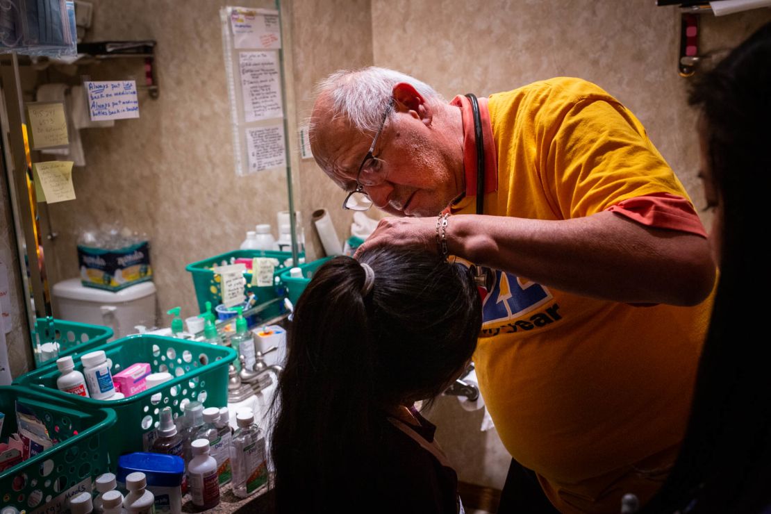 Dr. Carlos Gutierrez examines a young girl in a makeshift clinic at a shelter in El Paso.