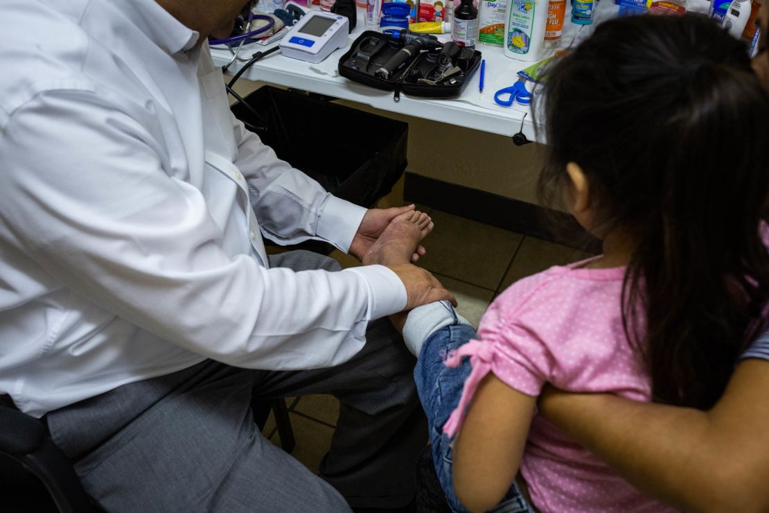 Dr. José Manuel de la Rosa examines a rash on 5-year-old Meliza's legs. 