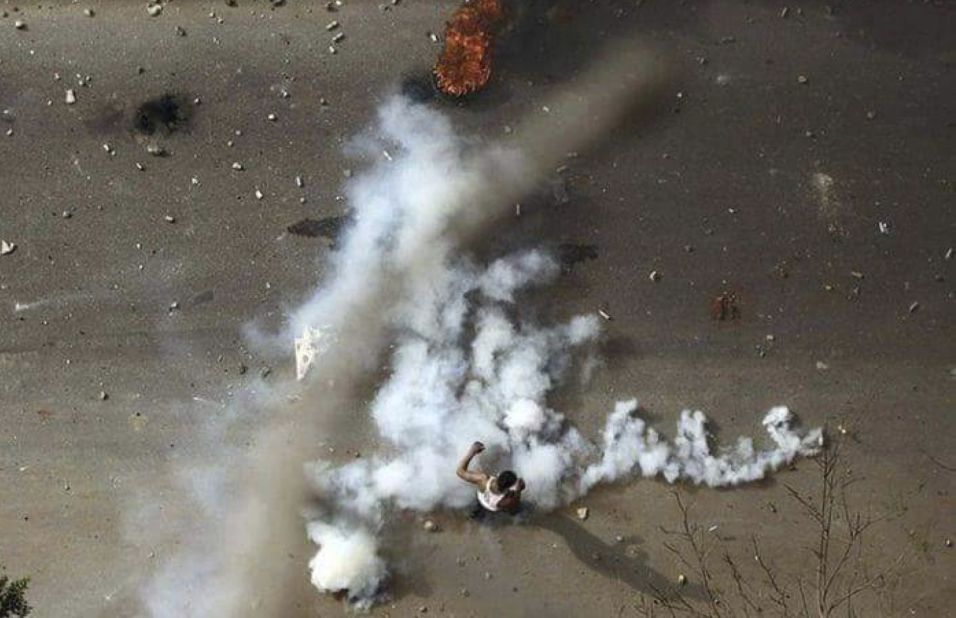 A protester is seen in the midst of tear gas during clashes with security forces in Khartoum in December 2018.