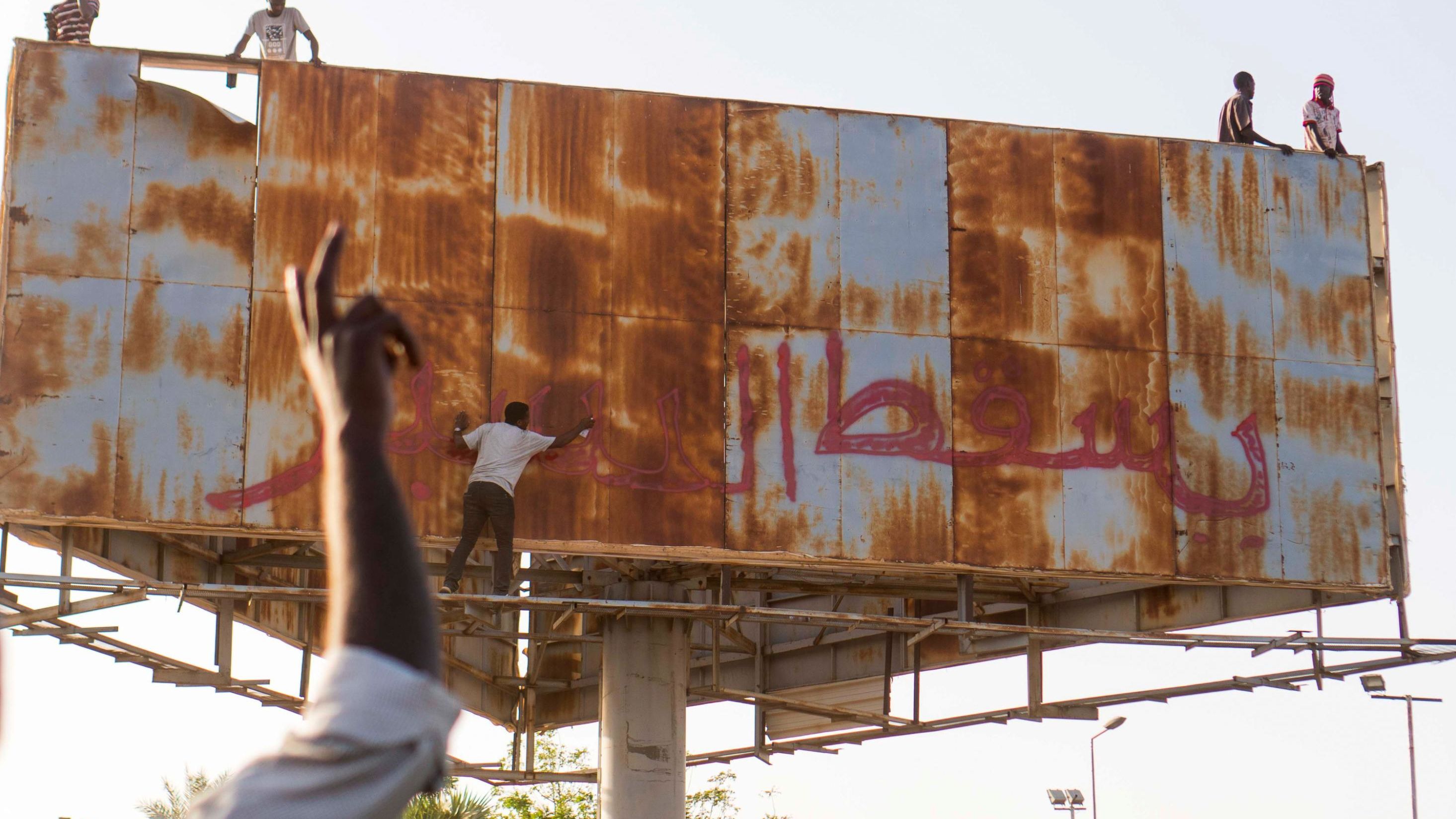 A person writes "Down with Bashir" during an April 9 demonstration in Khartoum.