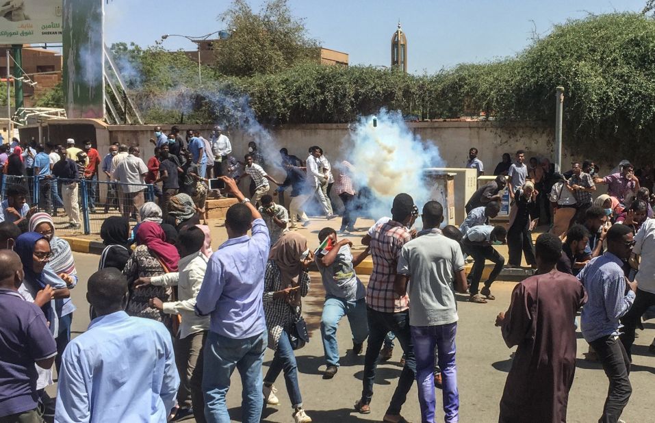 Protesters run for cover on April 6, as tear-gas canisters are fired by police.