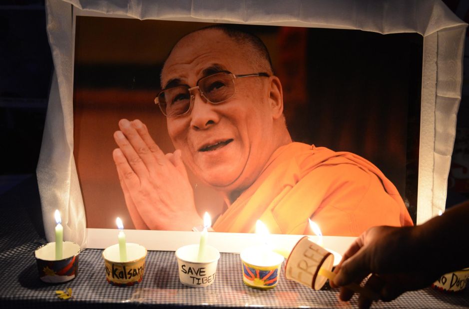 A Tibetan activist lights a candle in front of a poster of the Dalai Lama during a protest rally in Hyderabad, India, in March 2016. The rally marked the 57th anniversary of the Tibetan uprising.