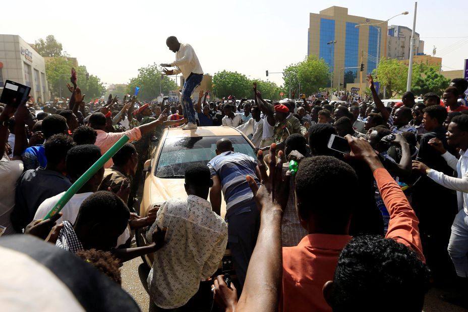Demonstrators block the vehicle of a military officer on April 11.
