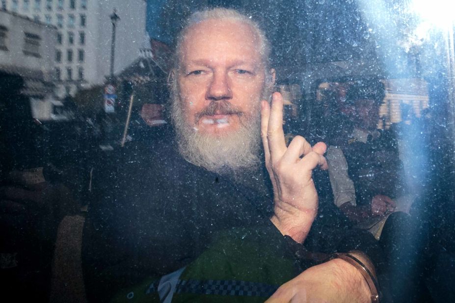 Julian Assange gestures from a police vehicle on his arrival at Westminster Magistrates' Court in London on April 11, 2019. Assange, founder of the website WikiLeaks, has been a key figure in major leaks of classified government documents, cables and videos.<br />