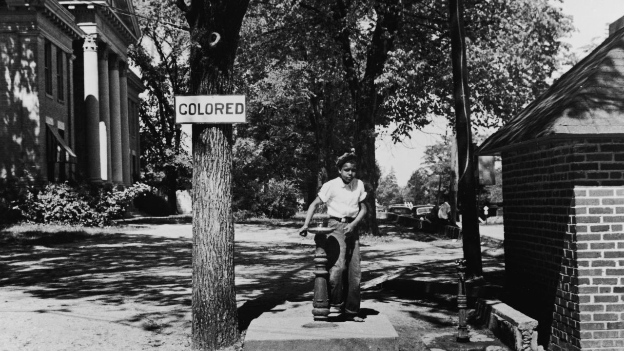 A young boy drinks from the "colored" water fountain on the county courthouse lawn in Halifax, North Carolina, in 1938. 