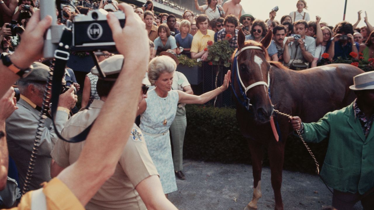 Fans look on as owner Penny Chenery gives Triple Crown winner Secretariat a pat.