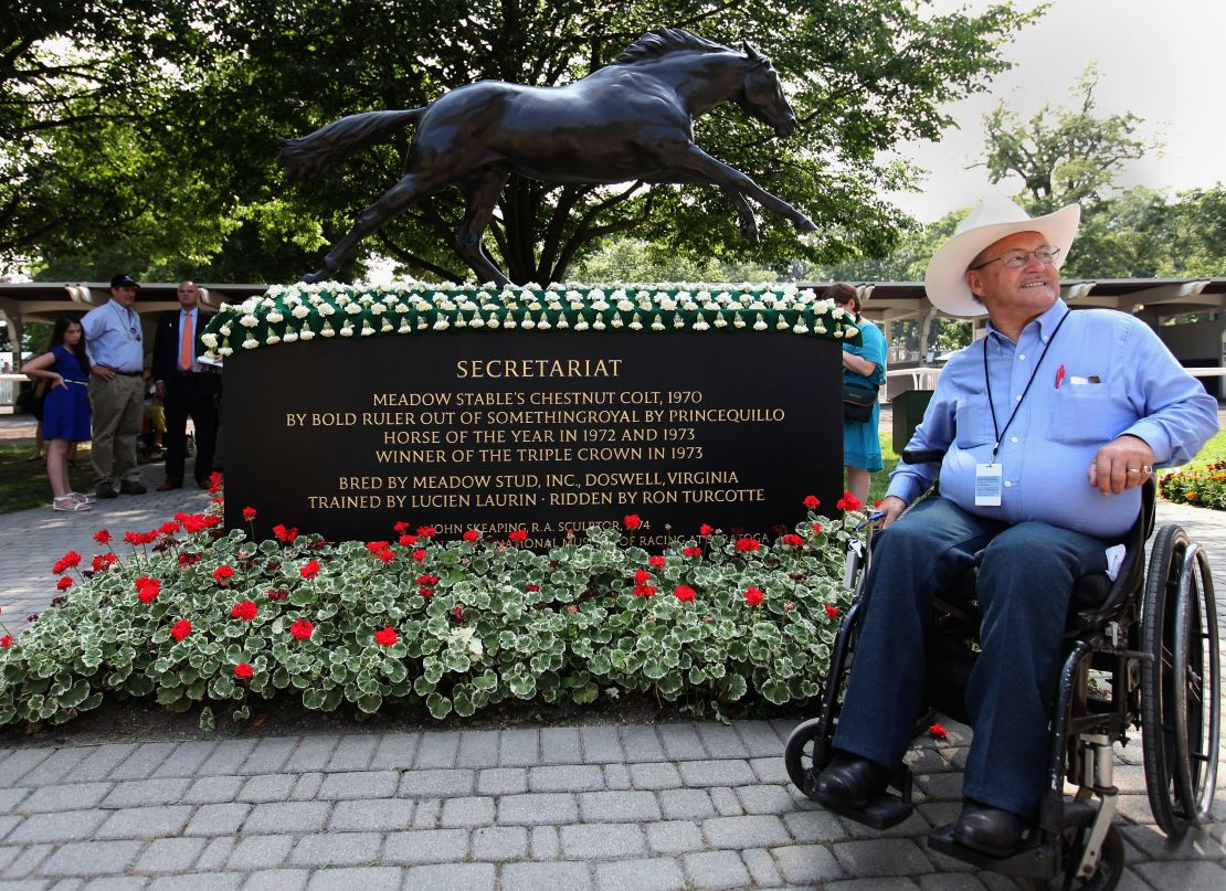 Ron Turcotte poses next to a statue of Secretariat at Belmont Park, USA. 
