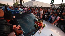People touch the hearse carrying the remains of rapper recording artist and social activist Nipsey Hussle, as it arrives outside at the Angelus Funeral Home, the terminus of a 25-mile procession, on April 11, 2019 in Los Angeles, California. - Hussle, born Ermias Ashgedom, was fatally shot outside his Marathon Clothing store in South Los Angeles on March 31, 2019. (Photo by Robyn Beck / AFP)        (Photo credit should read ROBYN BECK/AFP/Getty Images)