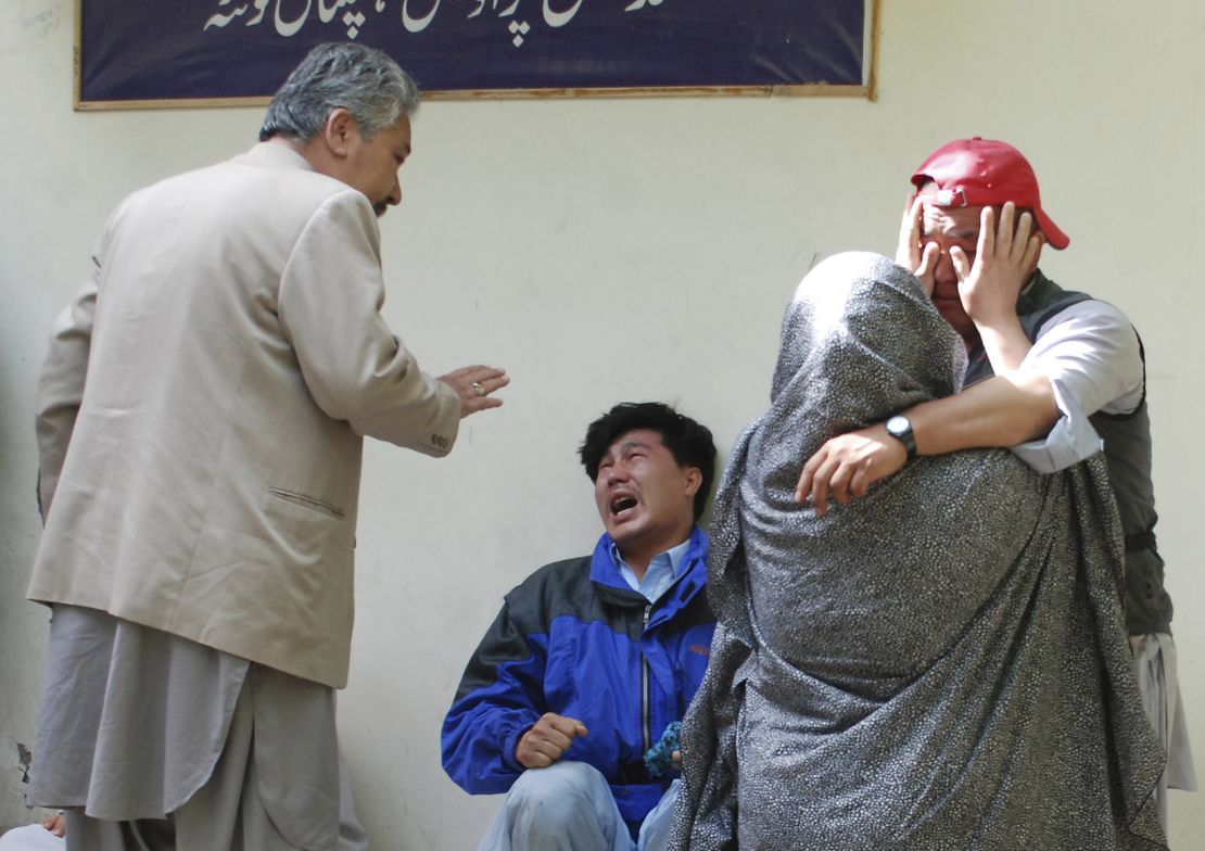 Family members of the blast victims comfort each other outside a mortuary in Quetta, Pakistan, after bomb went off at an open-air market in the southwestern city.