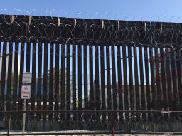 A section of the border fence with razor wire in Nogales, Arizona, looking south into Mexico.