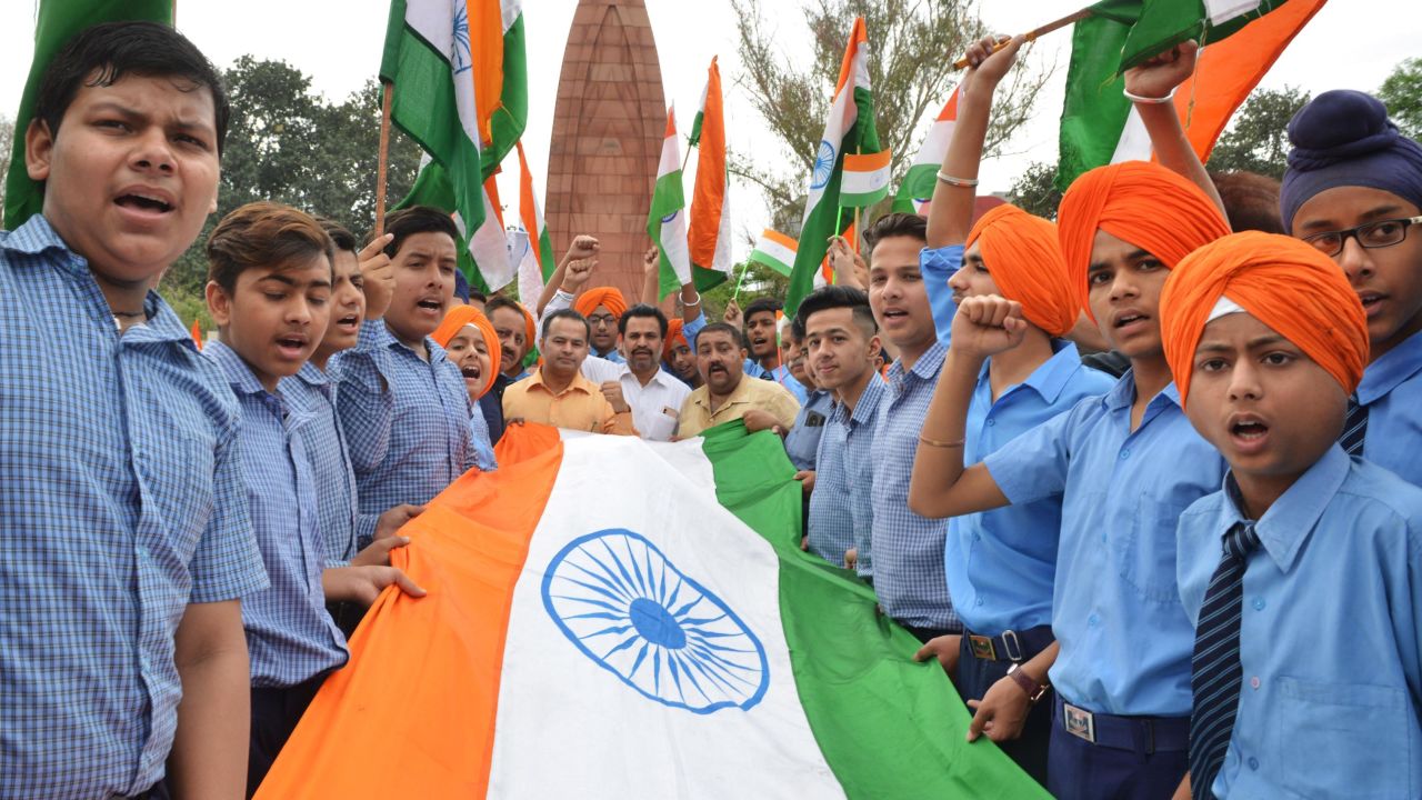 Indian school students hold the national flag in honor of the Jallianwala Bagh massacre, on the eve of the anniversary.