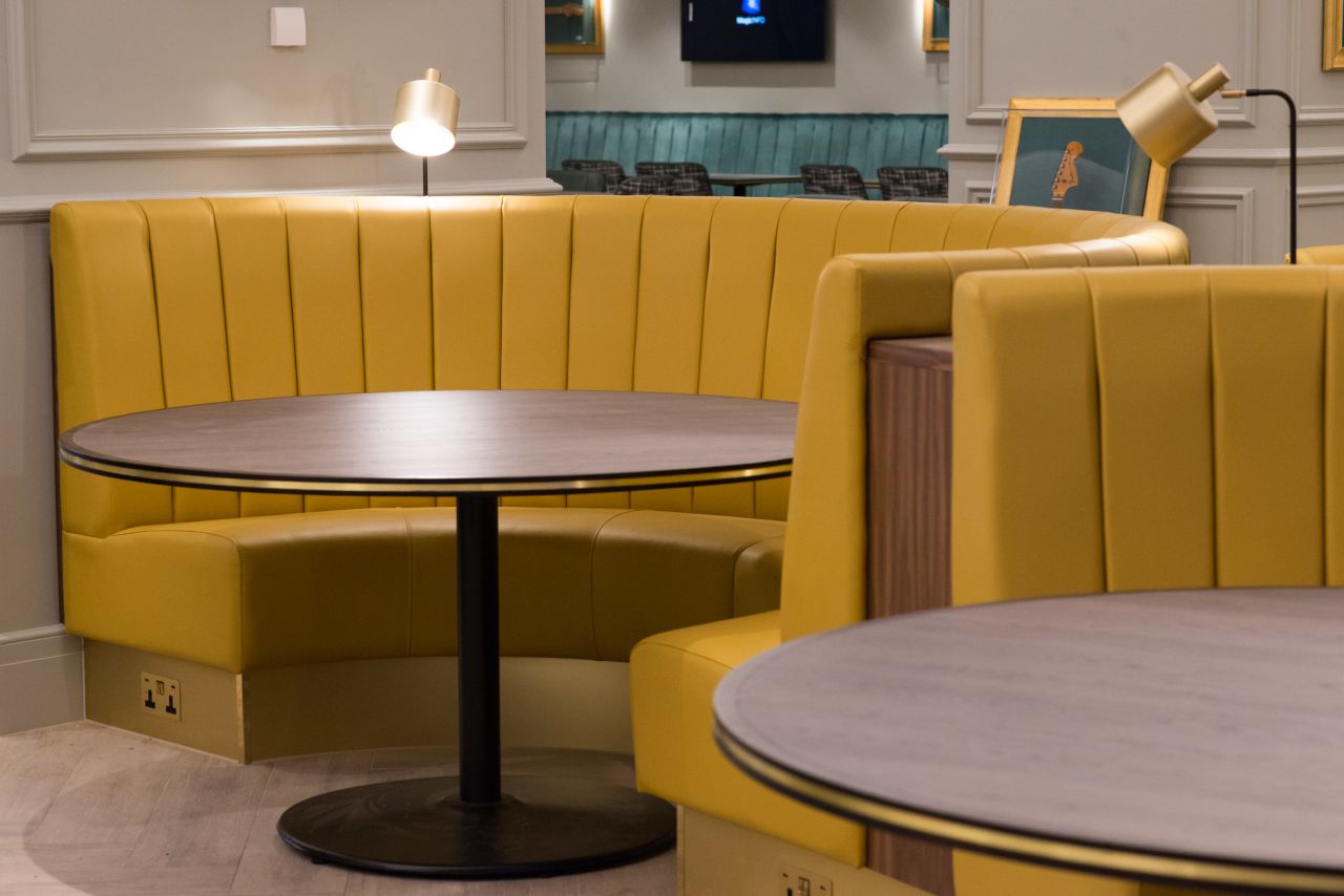 Yellow upholstered benches in the main dining room.
