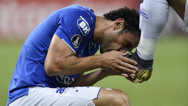 Fred, of Brazil's Cruzeiro, celebrates his goal against Argentina's Huracan, kissing the boot of teammate Marquinhos Gabriel during their 2019 Copa Libertadores football match at Mineirao Stadium, in Belo Horizonte, Brazil, on April 10.