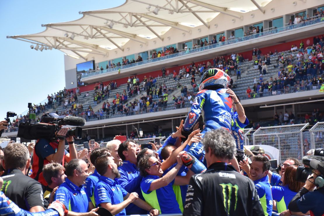 Young pretender Alex Rins held aloft by his team after his victory.