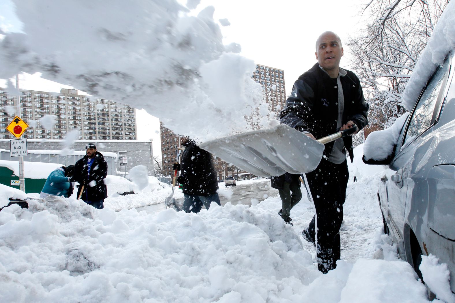 Booker shovels snow to help dig out people's vehicles in Newark in January 2011. While serving as mayor, Booker developed a reputation for engaging in personal acts of heroism such as rescuing a neighbor from a house fire and chasing down a suspected bank robber. Using social media to connect with constituents, he shoveled snowbound driveways by request and invited nearby city residents to his home when Hurricane Sandy caused widespread power outages.