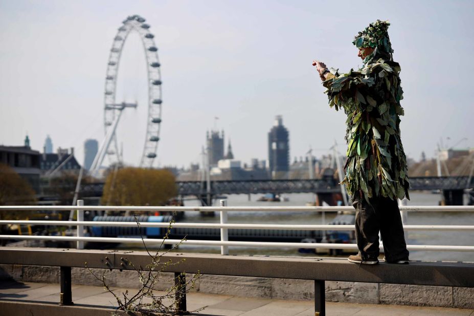 An environmental protestor stands on a barrier to take a picture on April 15.