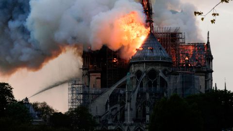 Flames and smoke are seen billowing from the roof at Notre-Dame Cathedral.