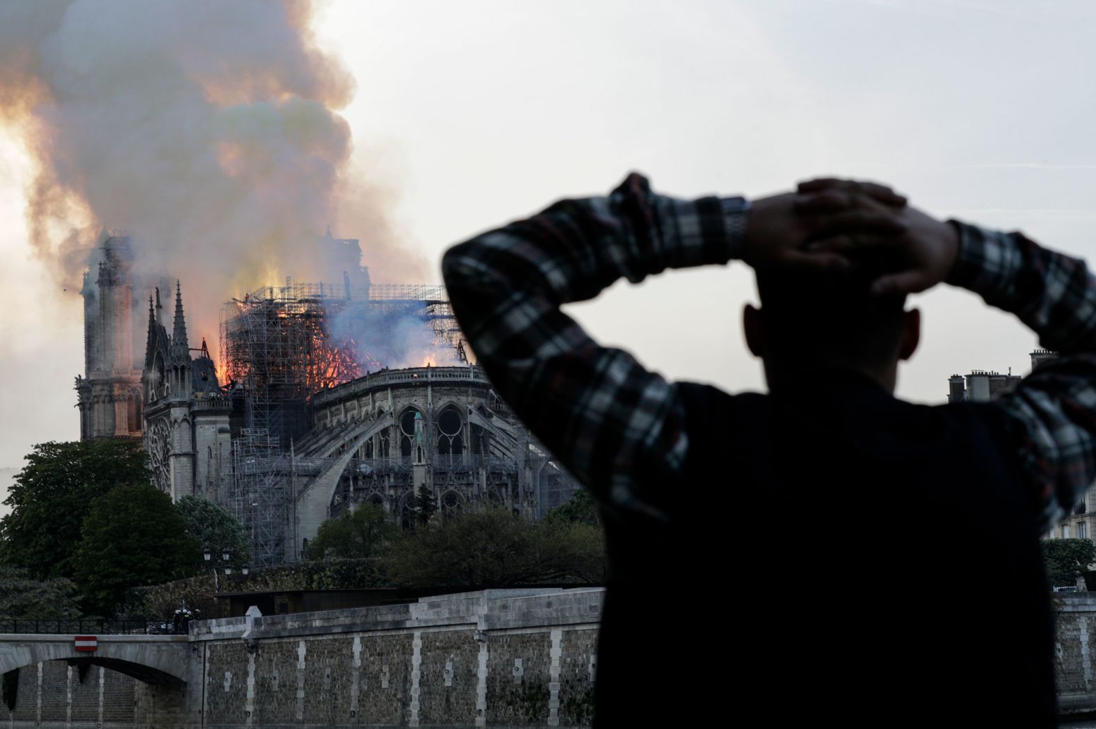 A man holds his head in shock as watches the fire take hold.