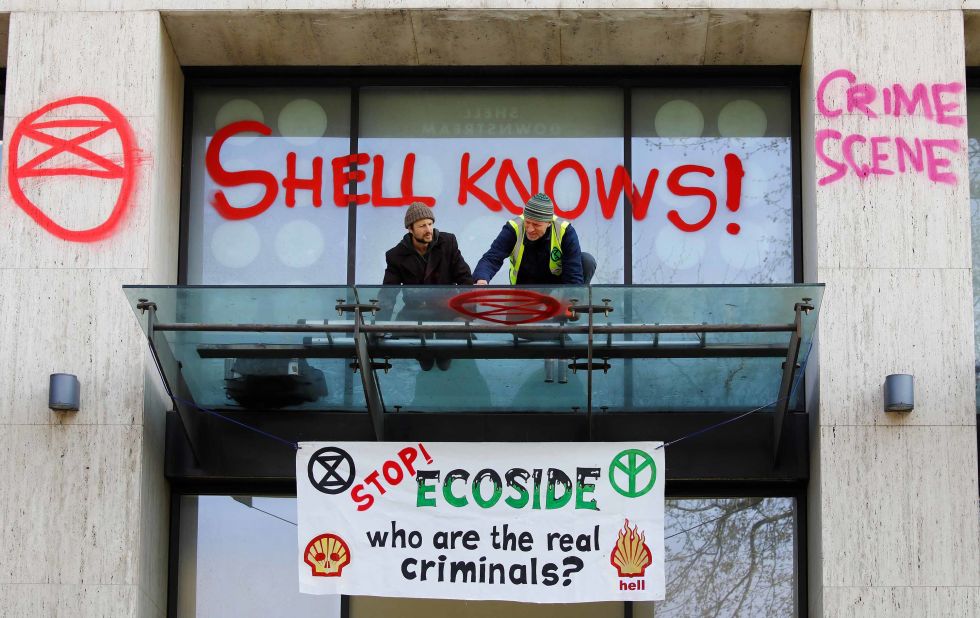 An activist sprays graffiti on an awning at the Shell Centre, offices of Royal Dutch Shell, as demonstrators surround the building during an environmental protest by Extinction Rebellion members on Monday, April 15.