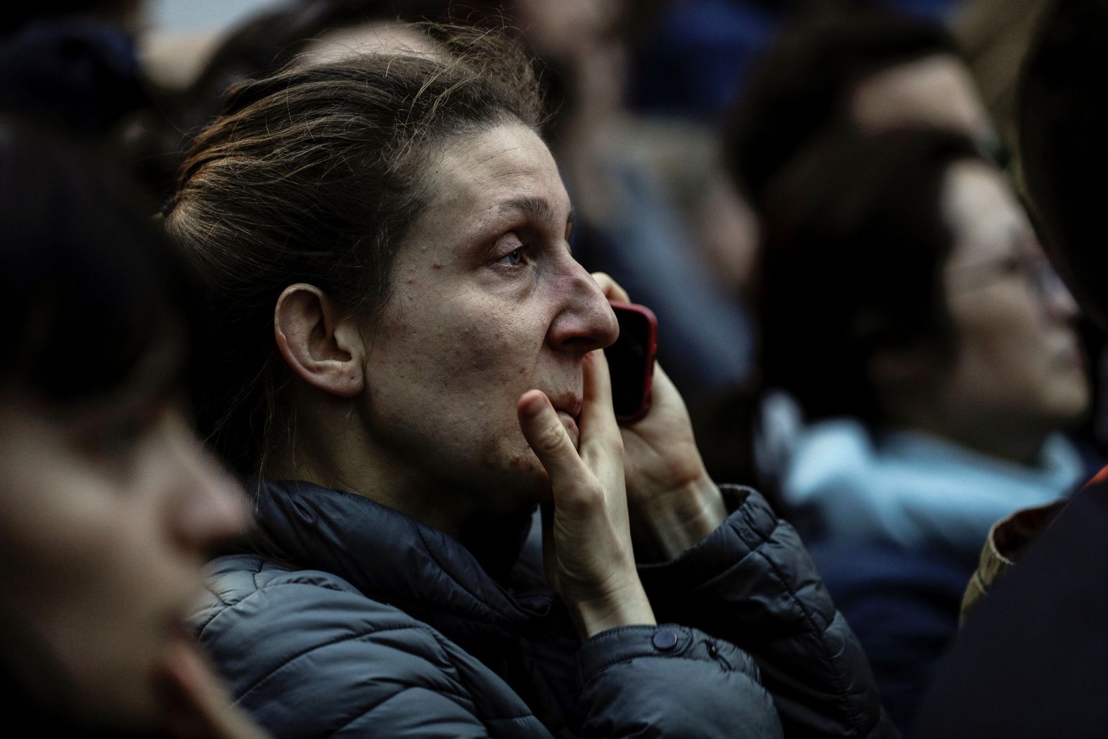 A woman reacts as she watches flames engulf the roof of the cathedral.