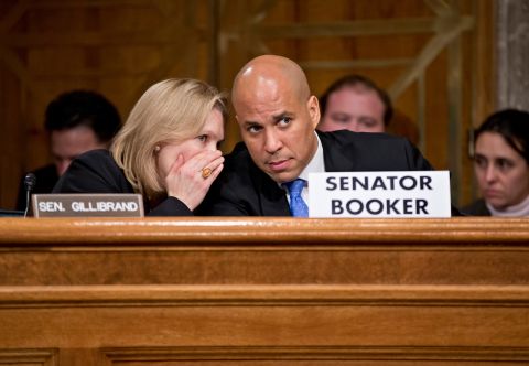 Booker confers with US Sen. Kirsten Gillibrand during a Senate subcommittee hearing in November 2013. The hearing, about Hurricane Sandy recovery efforts, was Booker's first since being sworn in.