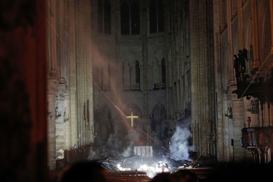 Smoke rises in front of the altar cross inside Notre Dame Cathedral.