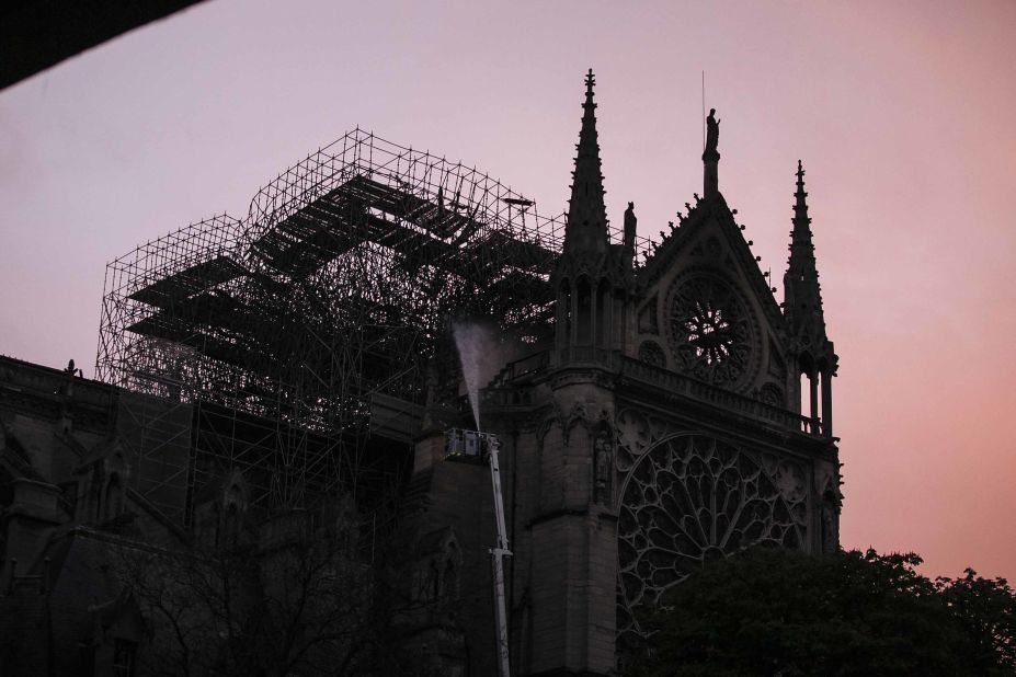 Notre Dame is seen at sunrise as firefighters continue to work at the cathedral on the morning of April 16.