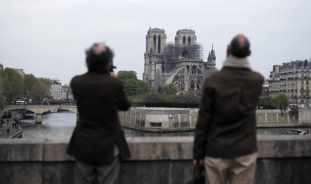 People stop to view Notre Dame Cathedral on the morning following the fire.