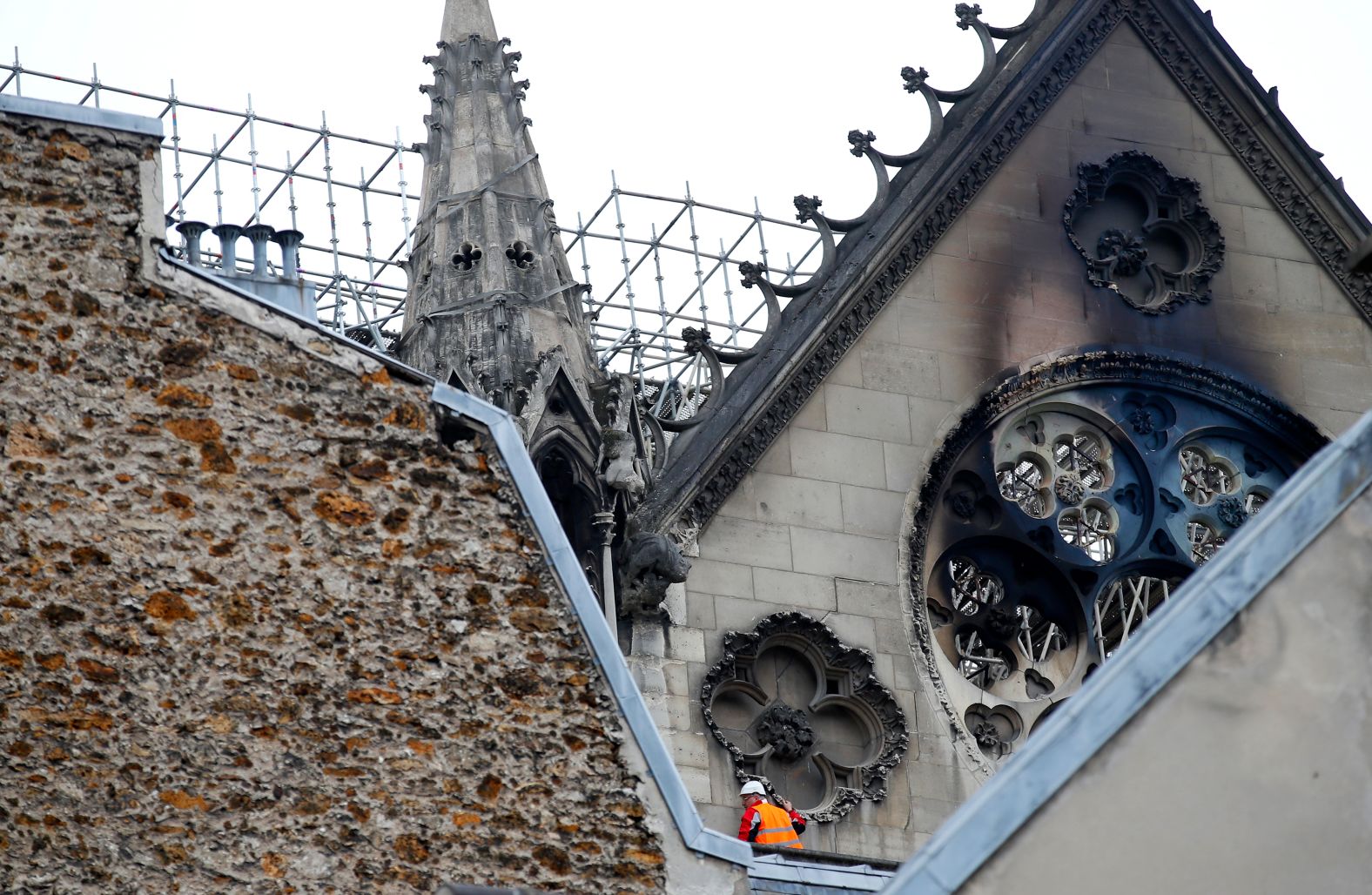 A man inspects damage near charred windows.