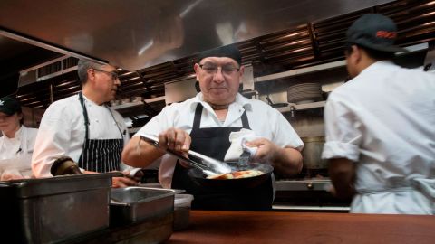 Chef Jacinto Guadarrama prepares dishes at Gotham Bar and Grill in New York, where hourly wages have gone up along with the city's minimum wage, to $15 as of the end of December.
