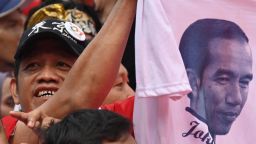 A supporter of incumbent Indonesian president Joko Widodo holds up a T-shirt with Widodo's portrait during an election rally on the final day of campaigning in Jakarta on April 13, 2019. - Hundreds of thousands Indonesians gathered at Jakarta's main stadium on April 13 to attend the last rally of President Joko Widodo, who will run against ex-military general Prabowo Subianto on April 17. (Photo by BAY ISMOYO / AFP)        (Photo credit should read BAY ISMOYO/AFP/Getty Images)