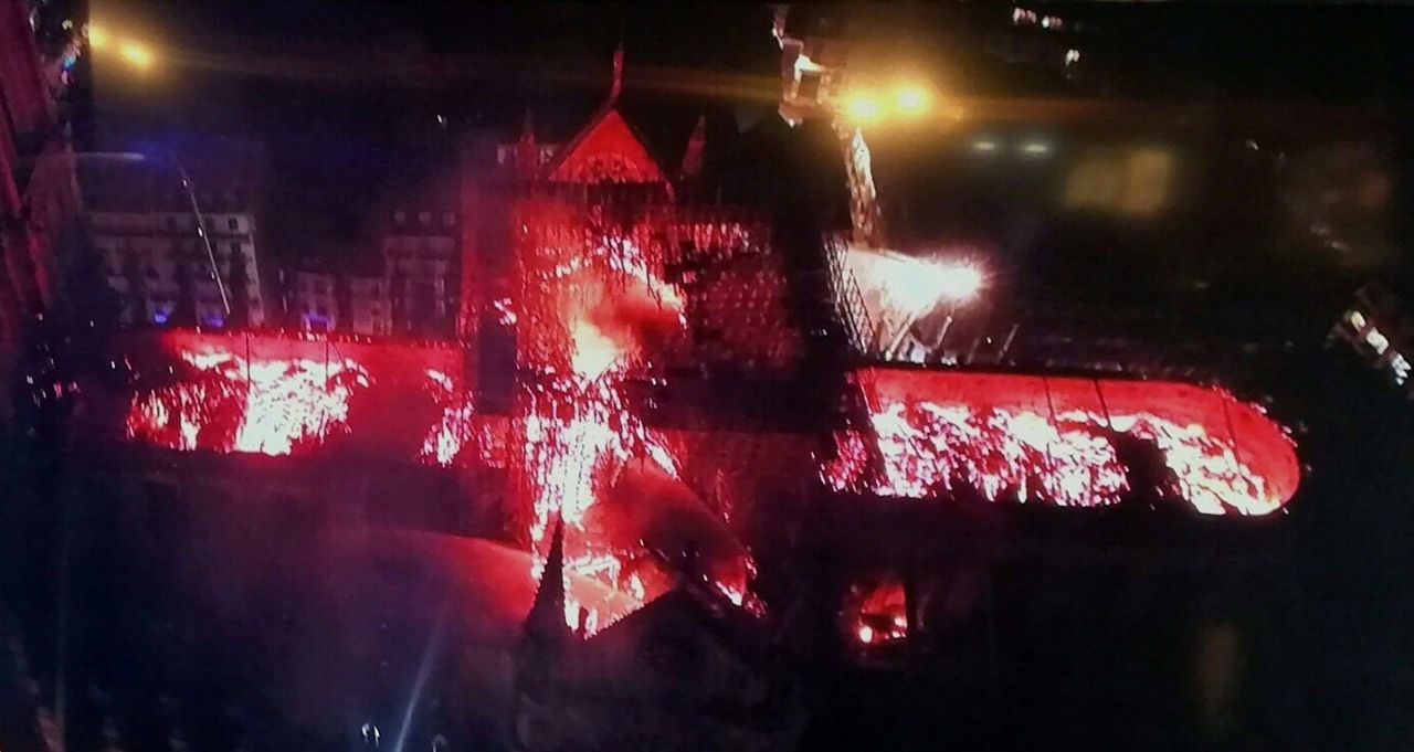 A handout image photographed on a television screen shows an aerial view of Notre Dame Cathedral engulfed in flames on Monday, April 15, 2019.