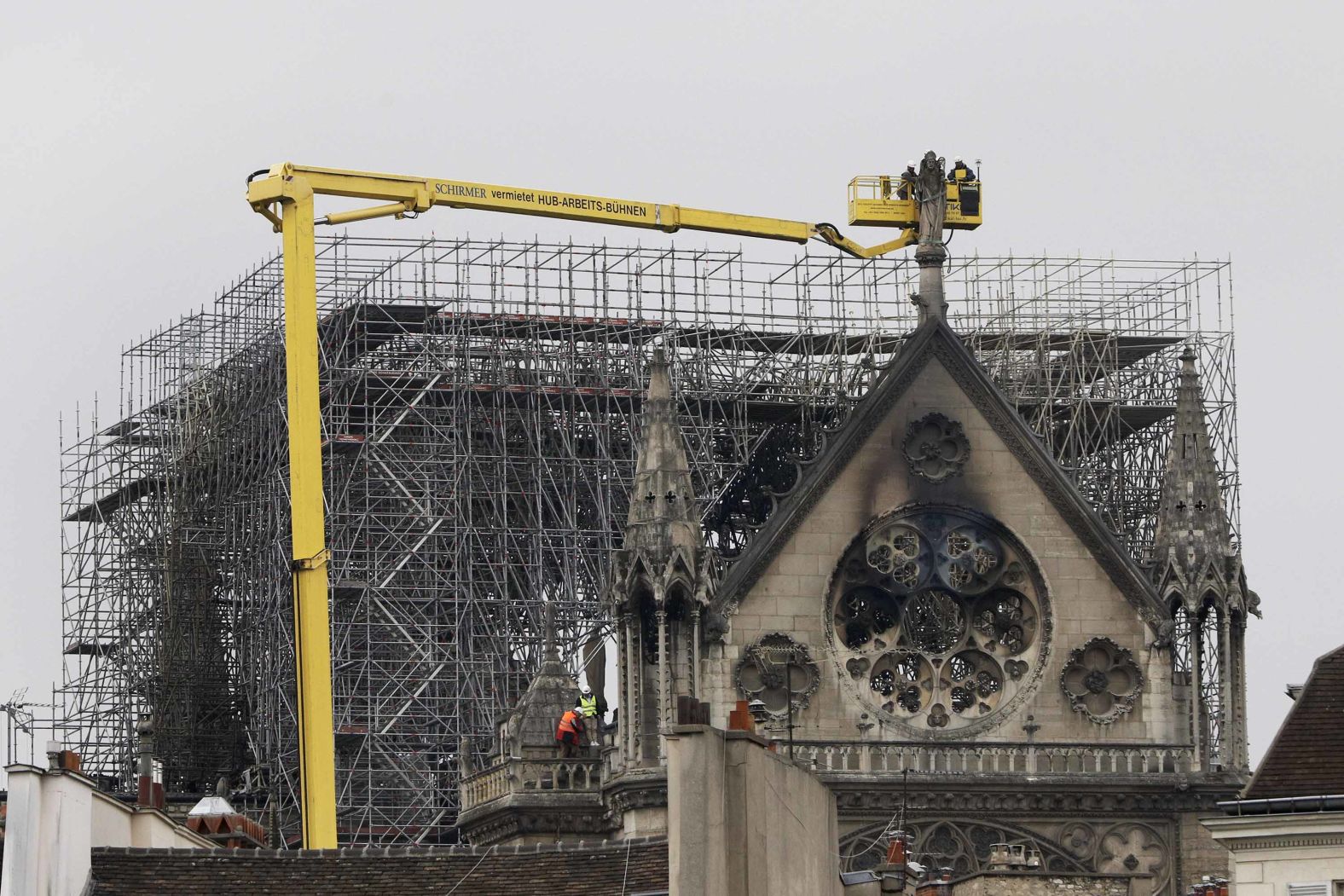 A crane lifts experts as they inspect the damage.