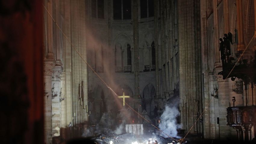 Smoke rises in front of the altar cross at Notre-Dame Cathedral in Paris on April 15, 2019, after a fire engulfed the building. - A huge fire swept through the roof of the famed Notre-Dame Cathedral in central Paris on April 15, 2019, sending flames and huge clouds of grey smoke billowing into the sky. The flames and smoke plumed from the spire and roof of the gothic cathedral, visited by millions of people a year. A spokesman for the cathedral told AFP that the wooden structure supporting the roof was being gutted by the blaze. (Photo by PHILIPPE WOJAZER / POOL / AFP)        (Photo credit should read PHILIPPE WOJAZER/AFP/Getty Images)