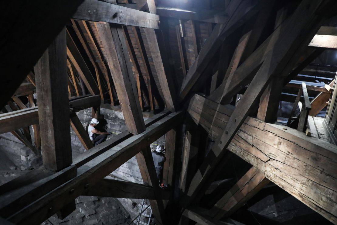 Workers measure a wall as they begin restoration work on a damaged section of the cathedral in 2018.