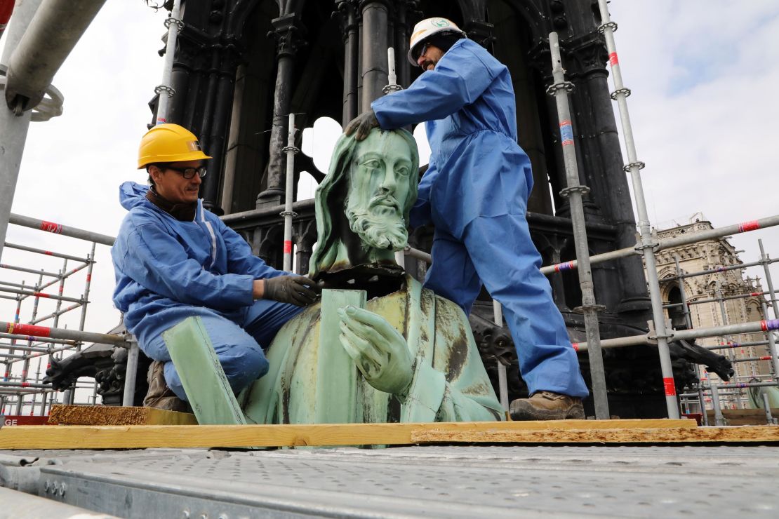 Conservationists remove the head of a statue, depicting the apostle Saint Andre, that was built by architect Eugène Viollet-le-Duc. The picture was taken in March 2019, less than a month before the devastating fire.