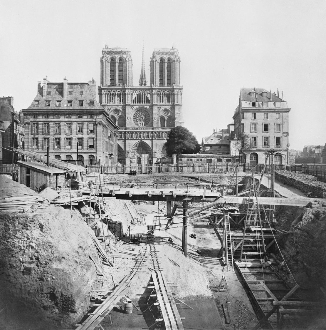 A 1864 image by Pierre-Ambroise Richebourg shows foundations being laid on a construction site near the Notre Dame Cathedral.