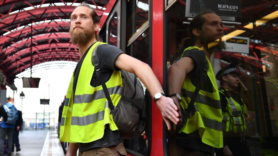 A climate change protester who glued his hand to a window halts a train at Canary Wharf station on Wednesday.